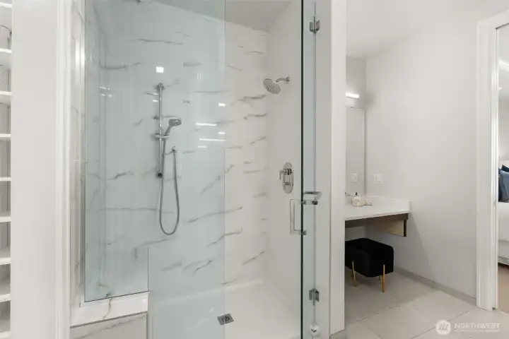 Designed for indulgence, the elegant bath offers a glass-enclosed shower with bench seating, two shower heads and a separate lighted vanity for elevated daily rituals. Designed for indulgence, the elegant bath offers a glass-enclosed shower with bench seating, two shower heads and a separate lighted vanity for elevated daily rituals.