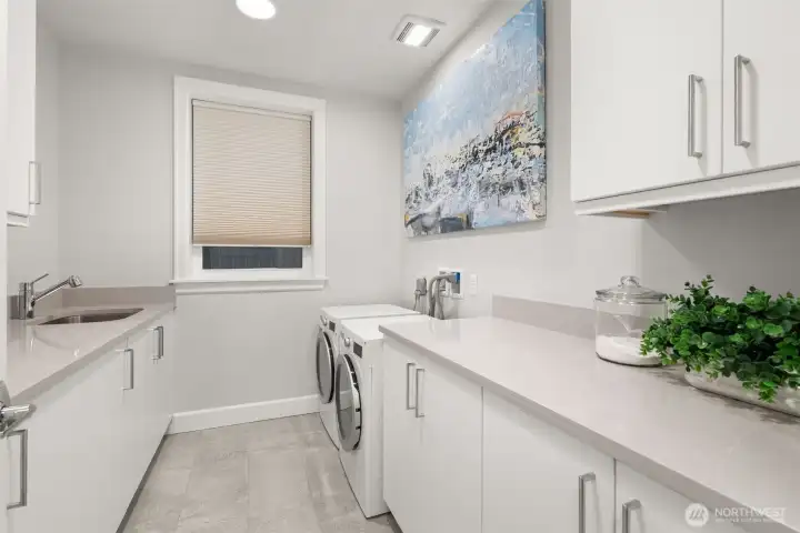 Thoughtfully designed utility/laundry room with sink, abundant cabinetry, and workspace. Thoughtfully designed utility/laundry room with sink, abundant cabinetry, and workspace.
