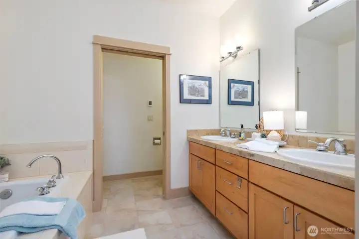 The primary bath has a double vanity, shower and soaking tub.