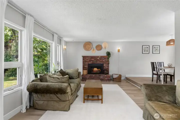 Large windows frame peaceful views of the surrounding landscape while filling the living room with natural light throughout the day. Large windows frame peaceful views of the surrounding landscape while filling the living room with natural light throughout the day.