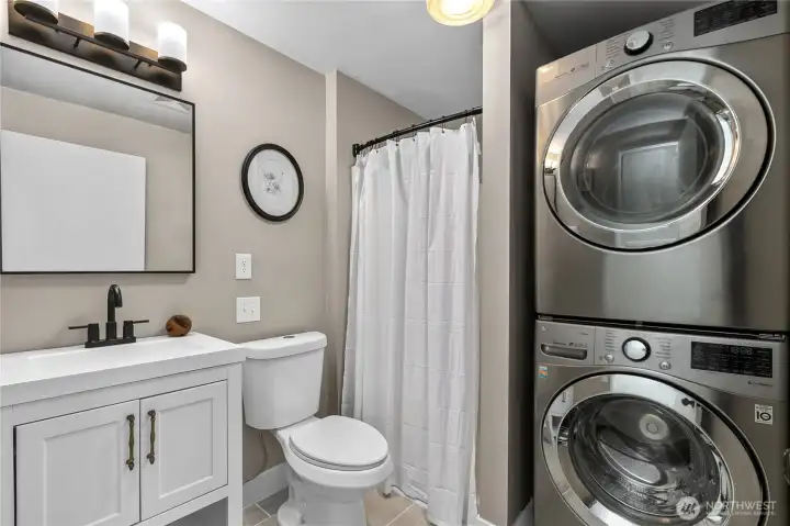 Convenient guest bathroom featuring updated fixtures and an integrated laundry area with stacked washer and dryer to maximize functionality. Convenient guest bathroom featuring updated fixtures and an integrated laundry area with stacked washer and dryer to maximize functionality.
