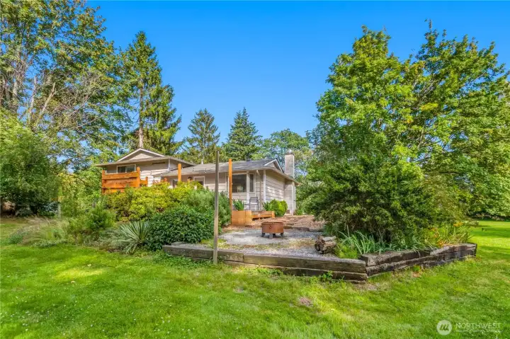 Fire pit area overlooks the expansive yard, providing a natural gathering place for evenings outdoors beneath the mature trees. Fire pit area overlooks the expansive yard, providing a natural gathering place for evenings outdoors beneath the mature trees.