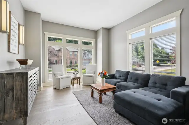Wrapped in natural light, this serene front sitting room offers a peaceful retreat for morning coffee, afternoon reading, or intimate conversations. Floor-to-ceiling picture windows frame views of the manicured streetscape, while wide-plank engineered oak floors and clean architectural lines add warmth and sophistication. An ideal space to recharge or welcome guests in effortless style