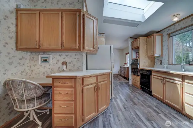 Skylights above along with the large kitchen window over the sink bring in joyful natural light.
