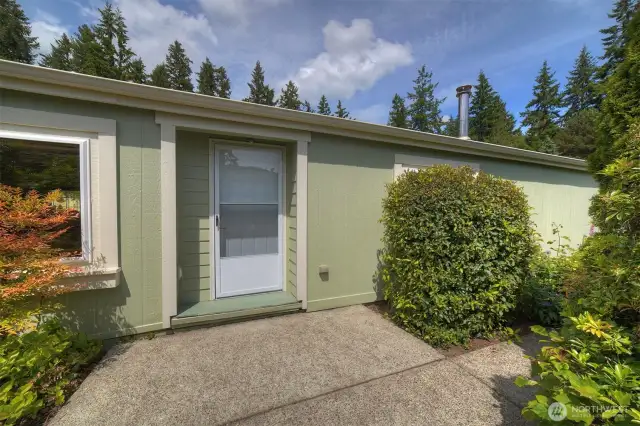 Take a walk along the pathway surrounded by established plantings leading to the traditional front door of the home.