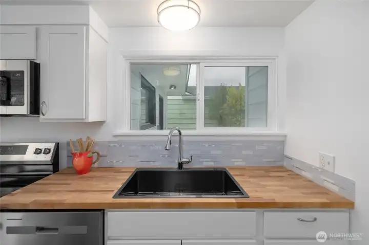 Kitchen with new sink and window that looks out over the patio.