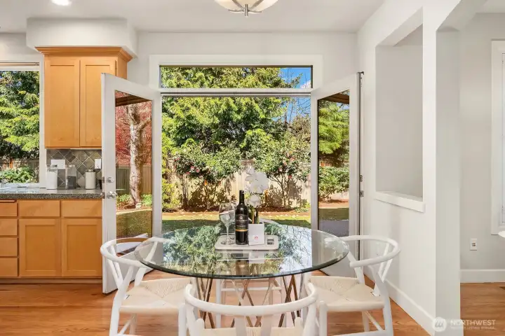 This sun-drenched breakfast nook is a delightful everyday retreat, featuring a large picture window that frames stunning garden views and floods the space with warm natural light. Perfectly positioned adjacent to the kitchen, this charming spot is ideal for morning coffee, casual meals, or simply enjoying the beauty of the lush, private backyard surroundings.