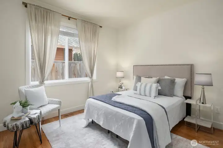 This charming main level bedroom offers a bright and comfortable retreat, featuring rich hardwood floors, fresh neutral finishes, and lovely window treatments that frame the natural light beautifully. Conveniently located on the main level with private access to a three-quarter bath, this versatile room is perfectly suited for guests, multigenerational living, or a dedicated home office.