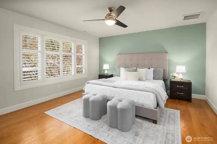 The serene and spacious primary bedroom offers a peaceful retreat with rich hardwood floors, soft neutral tones, and abundant natural light that creates a calm and restful atmosphere. Generously proportioned and impeccably finished, this luxurious haven provides the perfect escape, complemented by the dual-sided fireplace and direct access to the stunning five-piece bath just steps away.