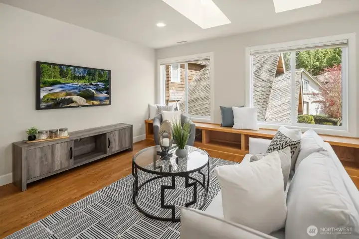 This alternate view of the expansive bonus room further highlights the abundant natural light pouring in through the skylights and large windows, creating a wonderfully bright and inviting atmosphere perfect for a wide variety of uses. The hardwood floors, ample space, and flexible open layout make this exceptional room a truly rare find that adds tremendous value and livability to this already outstanding home.