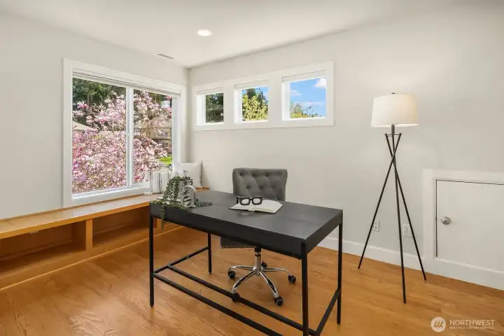 This bright and inspiring home office or study features rich hardwood floors, built-in bench seating, and a charming window with beautiful flowering garden views that create the perfect backdrop for productive work-from-home days. Quietly tucked away yet easily accessible, this versatile space offers the ideal balance of functionality and comfort for today's modern lifestyle.