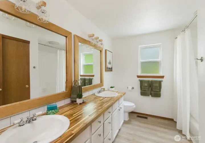 Primary bedroom has the tallest view inside the house. The attached Primary Bathroom is updated with new double vanity, counters, lights, mirrors.  The bath tub has tiled walls & a deep linen closet.