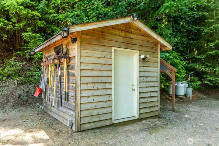 Pump House with 2 pressurized tanks for your private well, also houses the Solar system's Battery Bank.  Inside there is also a wprk bench and space for tools.