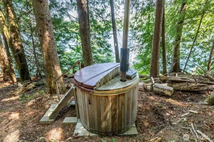 Living lavishly off grid includes making your way under a canopy of Evergreen trees that provide a curtain of privacy, you'll find your wood burning Cedar Hot Tub.