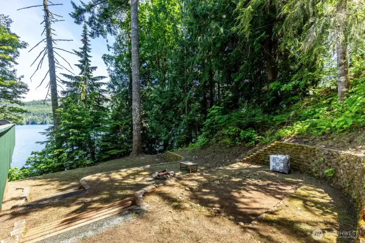 3 tiered retaining walls creates terrances for different activities like archery, a fire pit or yard games like Corn Hole. Archery Target, Cornhole and bench convey with the sale of the house.