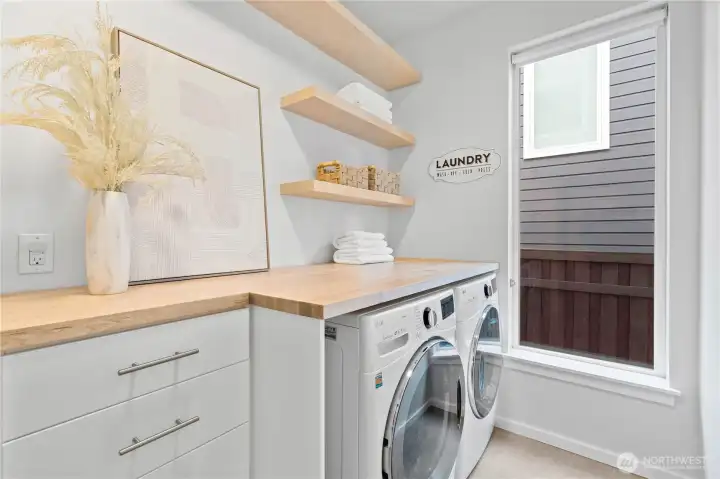 Main floor laundry room, with built in cabinets for more storage. Highlighted by large window to let in the light.