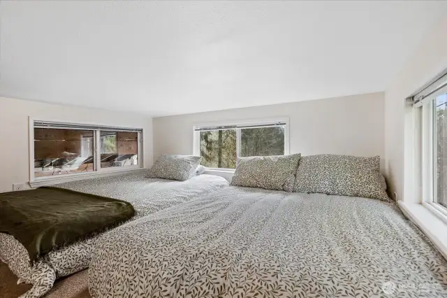 Loft with couch and three beds.