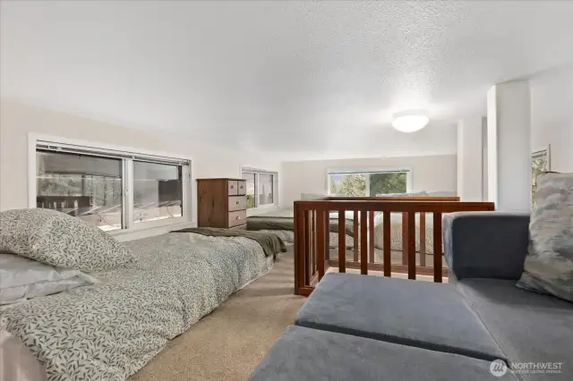 Loft with couch and three beds.