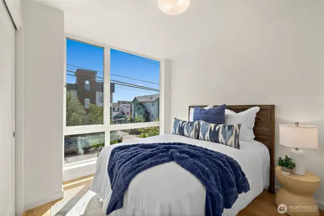 2nd bedroom on the South side of the home with floor to ceiling windows, hardwood floors and new interior paint throughout.