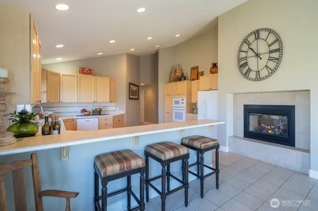 Bright and open kitchen with eating area and see through fireplace.