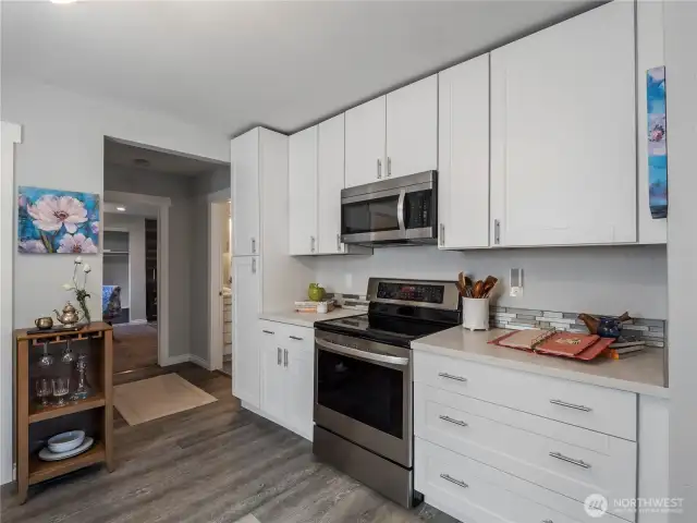 White counter tops and stainless steel appliances that all convey with the home.