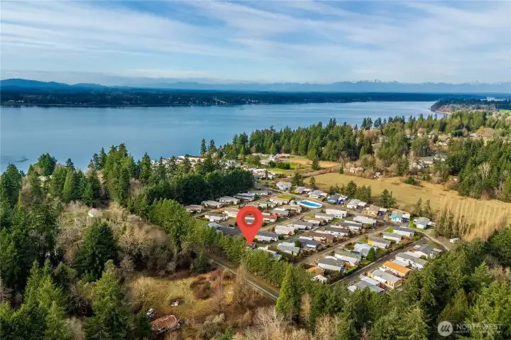 Aerial view highlights the peaceful coastal setting, surrounded by evergreens and just moments from the Puget Sound.