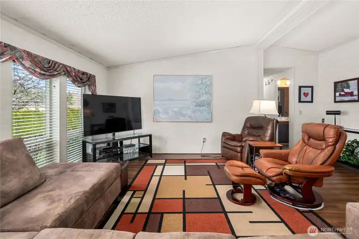 Inviting seating area is complemented by vaulted ceilings & double-paned windows with blinds throughout, creating a comfortable and light-filled space to relax and unwind.