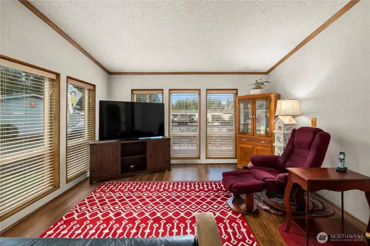 Light-filled den offers flexible space for relaxing, reading, or enjoying views of the surrounding greenery.