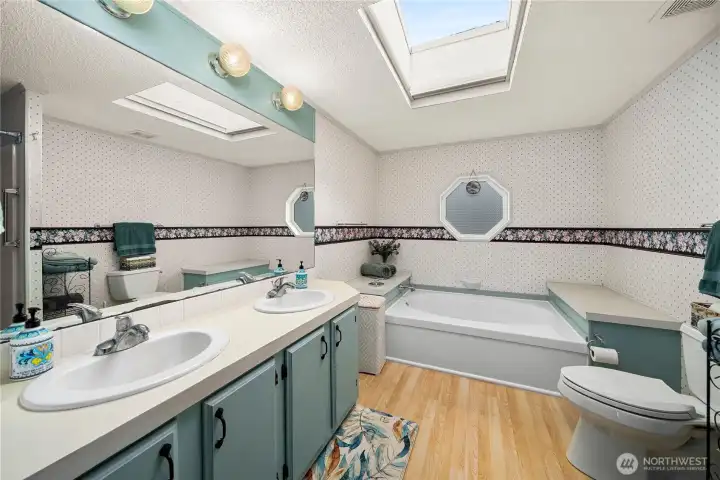 Primary bathroom includes dual-sink vanity, NEW skylight, soaking tub, walk-in shower and ample space for a bright, functional daily routine.