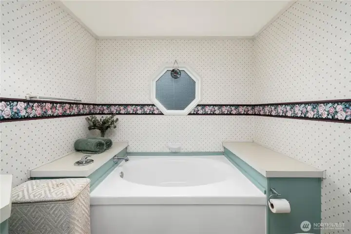 Soaking tub offers a relaxing space to unwind, enhanced by natural light and a serene spa-like feel.