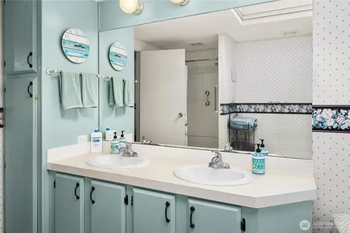 Enjoy the spacious dual vanity & towel cabinet with ample storage and soft coastal tones.