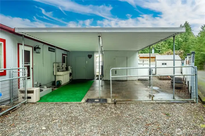 Covered, gated carport provides protected parking PLUS 2 sheds for additional storage.