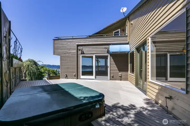 The side deck walks out from the family room on the right or the dining room ahead. The primary bedroom view deck is above. This deck is on the south side of the home for good sun exposure.