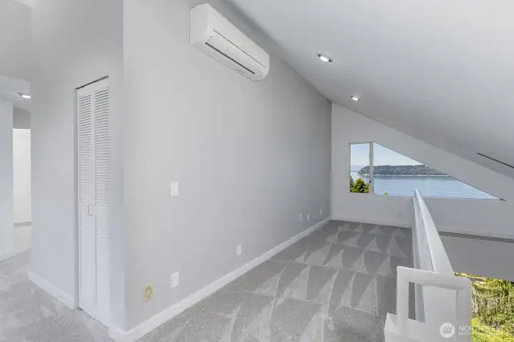 Looking from the top of the stairs to the second level through theoffice space to the view. There is a mini-split here and in the primary bedroom that provide cooling when needed.