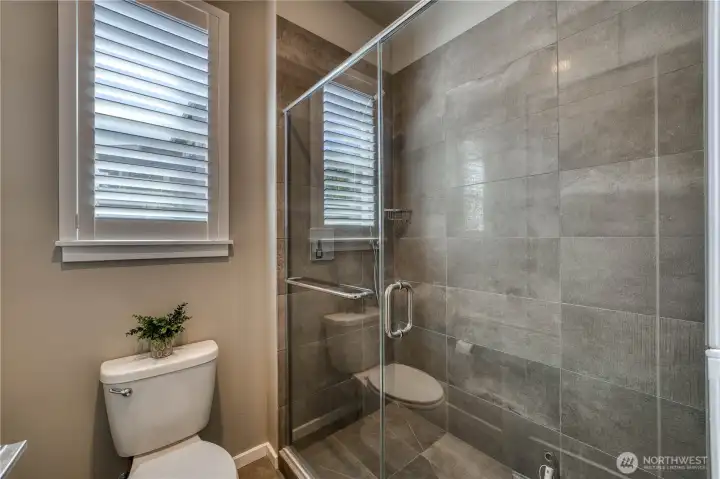 Guests shower in style in this upgraded tile shower with glass door.