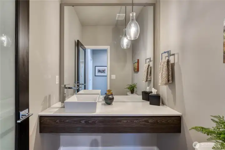 Stylish powder room with sleek vessel sink.