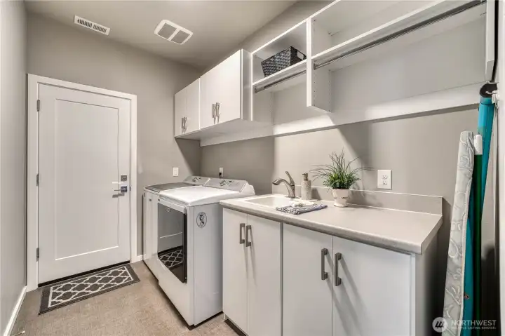 Lots of cabinets, room to hang clothes and a deep sink in the laundry room.