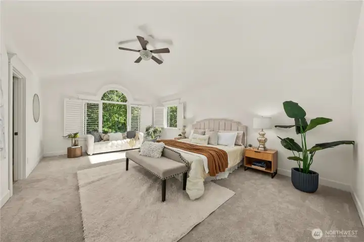 Expansive primary suite designed as a true private retreat, featuring vaulted ceilings, abundant natural light