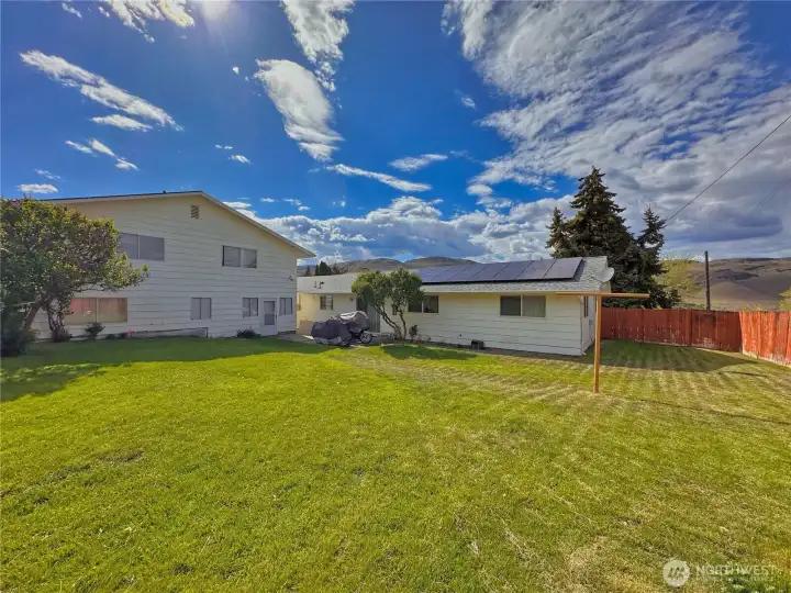Large, fully fenced backyard featuring patio area, and convenient access to the ADU and shop.