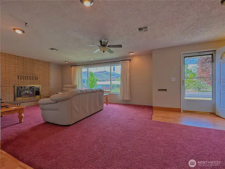 Living room featuring an electric fireplace insert and a large picture window that frames scenic mountain views.