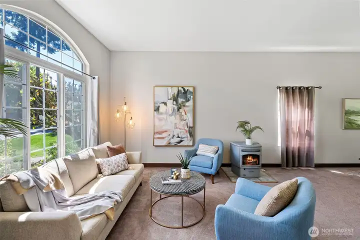 A beautiful arched window and pellet stove accents the living room space beautifully.