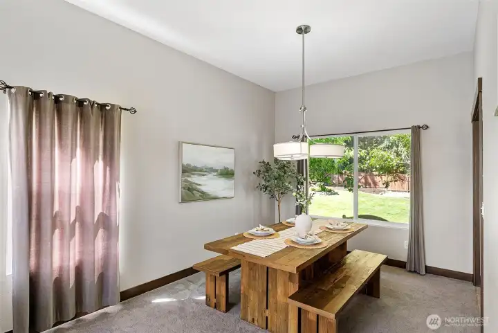 A dining room enjoys views to the beautiful, fully-fenced, private backyard.
