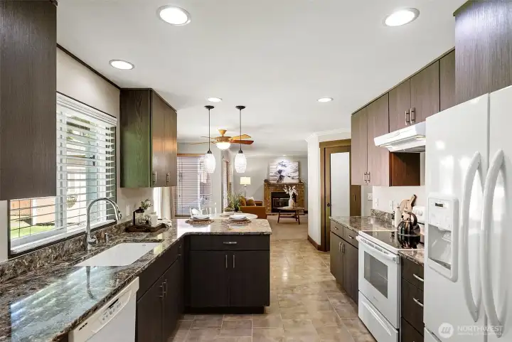As you enter the kitchen from the dining room, you will notice all the upgrades, including gorgeous quartz countertops, refreshed cabinetry, and ceramic tile flooring. A no-edge sink adds to easy cleanup.