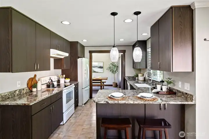 This kitchen has a lovely layout, making it easy for prepping meals while enjoying guests. Can lighting keeps things light and bright, and the gorgeous quartz counter tops are a beautiful touch.