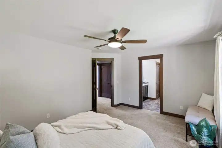 The primary bedroom enjoys its own bathroom with large shower, double vanity, and walk-in closet.