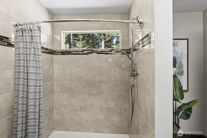 A large tiled shower is a part of the primary bath.