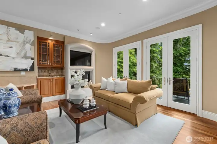 The living room beckons you to gather friends around the fireside, with a wet bar for easy hosting & even more French doors opening for al fresco enjoyment. The living room beckons you to gather friends around the fireside, with a wet bar for easy hosting & even more French doors opening for al fresco enjoyment.