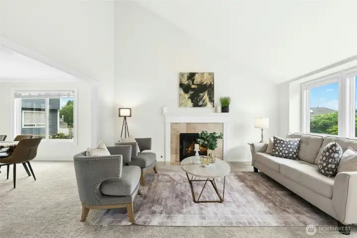 Living room with lots of light, vaulted ceiling and cozy fireplace.