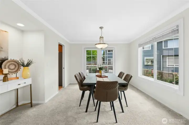Dining room with french doors open to a deck and gorgeous backyard.
