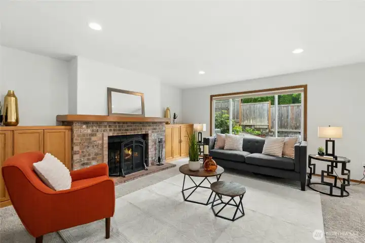 Spacious family room is much larger than you'd expect so there's room for everyone to gather around the brick fireplace.